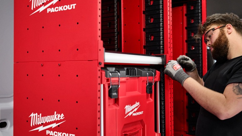 A worker assembles a Milwaukee Packout Rack kit