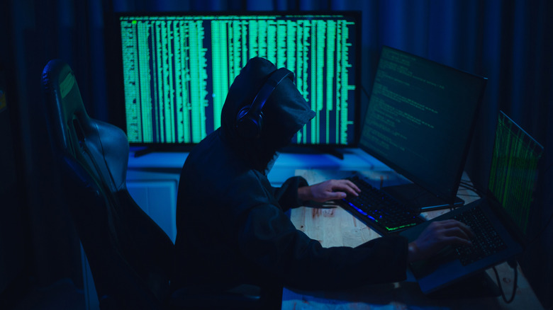 A person using multiple monitors to hack.