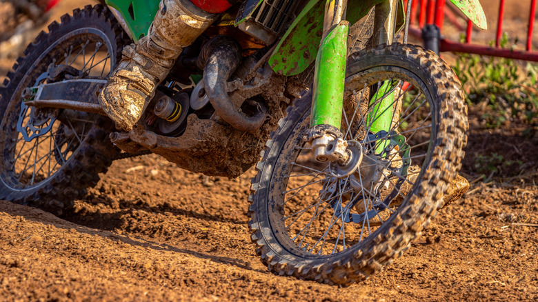Dirty and muddy off-road motorcycle riding during an off-road race