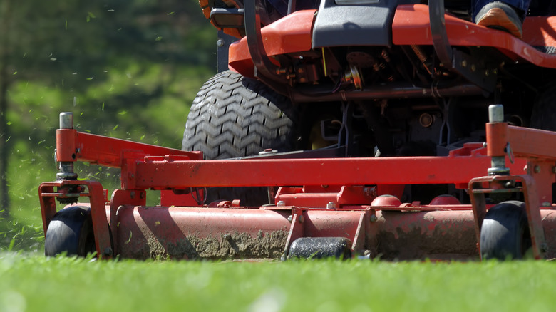A person cutting grass on a riding mower.
