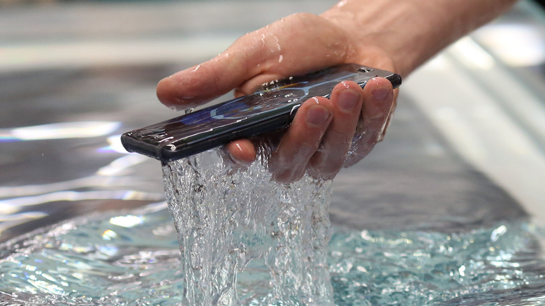 Man holding wet Samsung smartphone