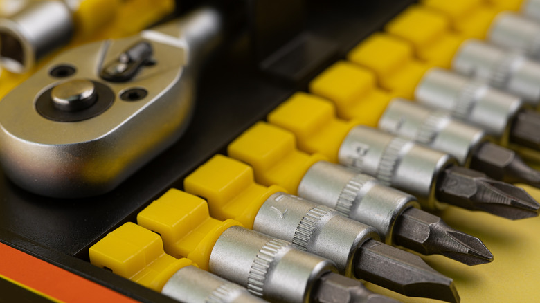 Close-up of several screwdriver bits and a ratchet handle