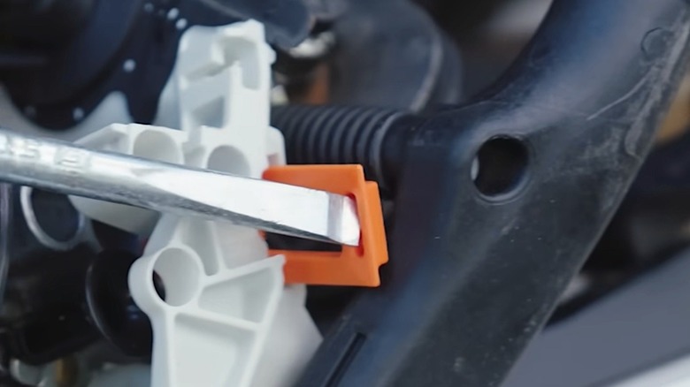Person removing the summer/winter shutter on their Stihl chainsaw