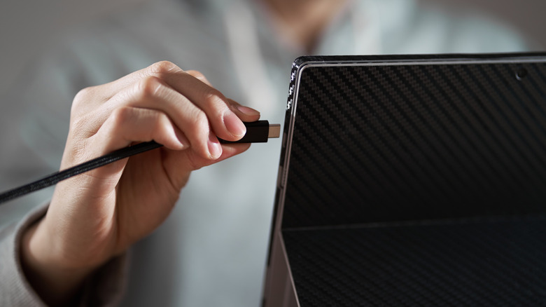 Person plugging USB C cable into device