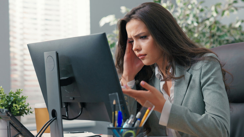 A woman frustrated at a monitor