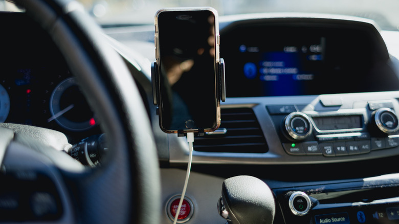 Smartphone in a holder mounted to a car dashboard