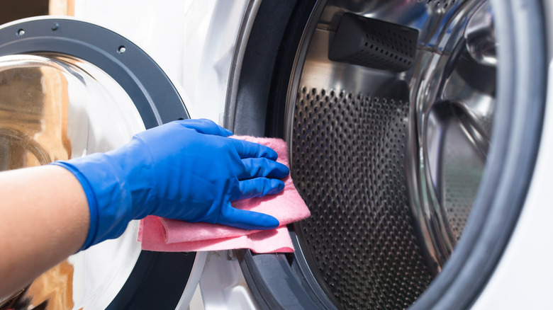 person cleaning inside washing machine