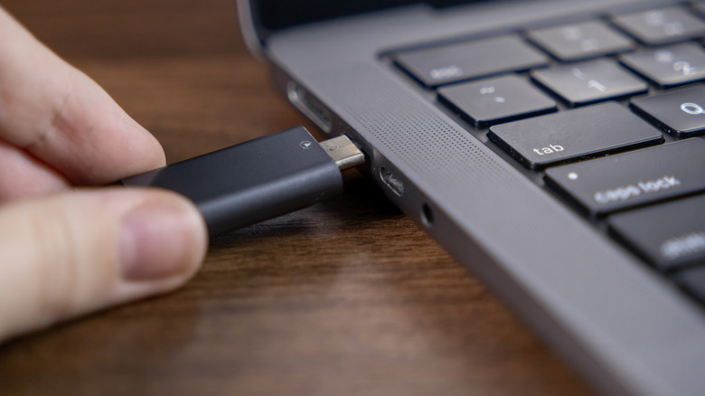 inserting usb flash drive into laptop port for data transfer and storage