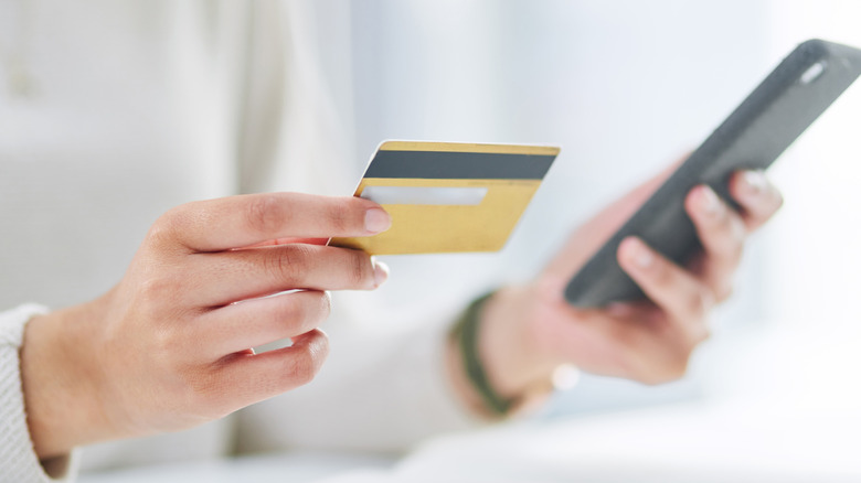 A person using credit card to make a purchase on a phone