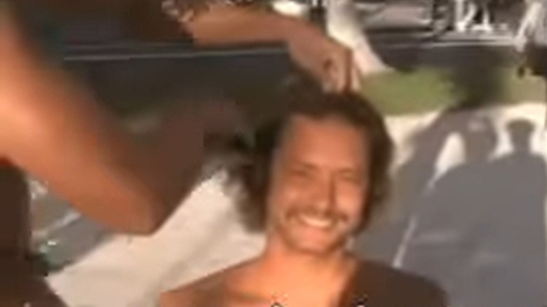 People shave a man's head