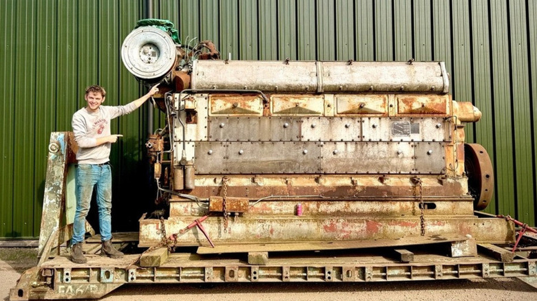 A shot of the 102.4-liter diesel engine with Mr. Hewes standing next to it and pointing