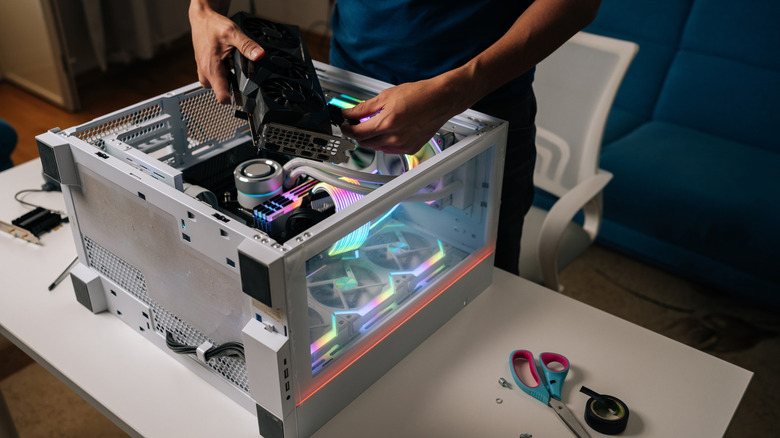 A technician installs a graphics card inside a desktop PC