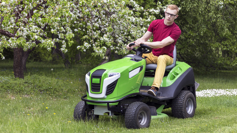 A man mows a lawn on a riding mower