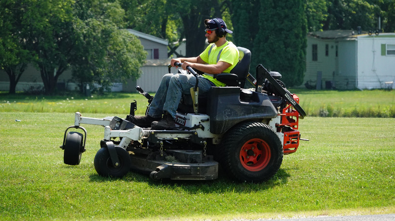 A man mows a lawn in a zero turn mower