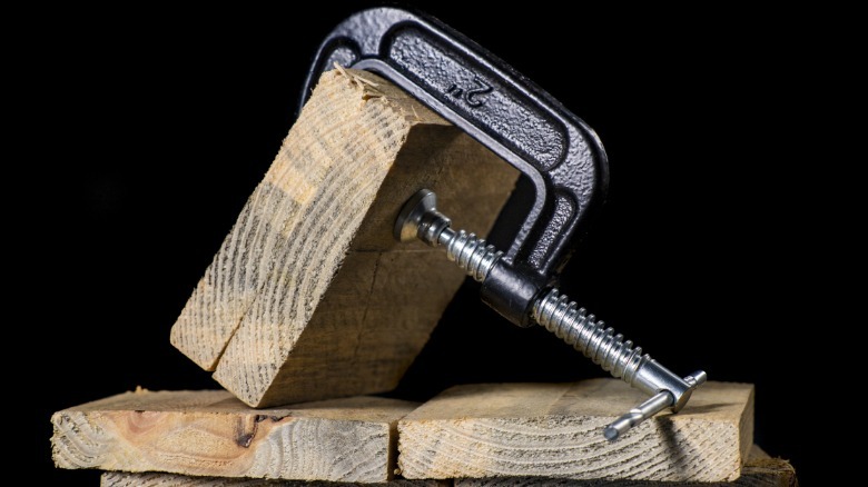 A c-clamp holding wood pieces together.
