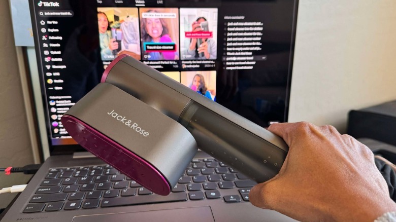 Author is holding up the Jack & Rose garment steamer in front of a laptop showing tiktok search results for the product
