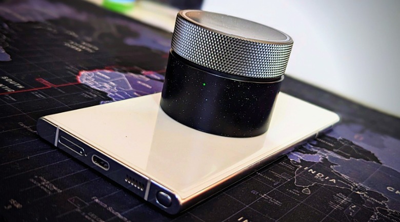 Angry Miao earbuds atop phone.