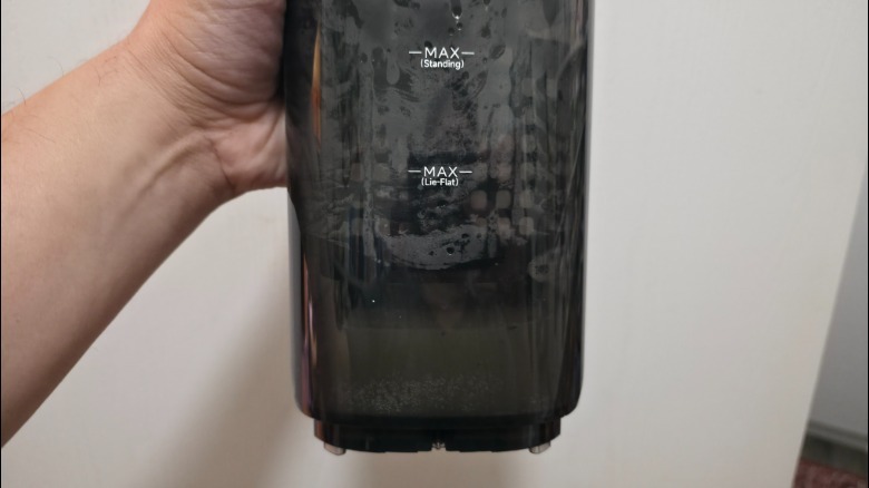 A person holding the dirty water tank from the Aero Ultra Steam