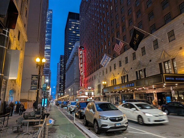 Exterior night street scene with cars and flags