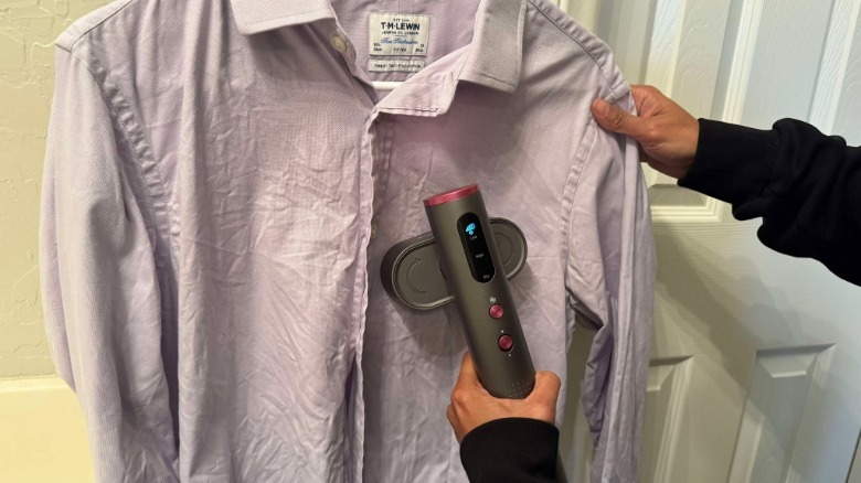 Author is using the steamer to iron a wrinkly dress shirt