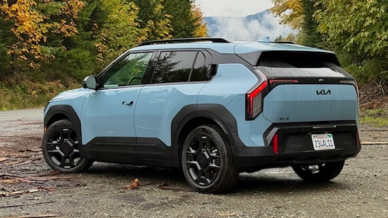 2027 Kia EV3 rear 3/4 parked in the woods