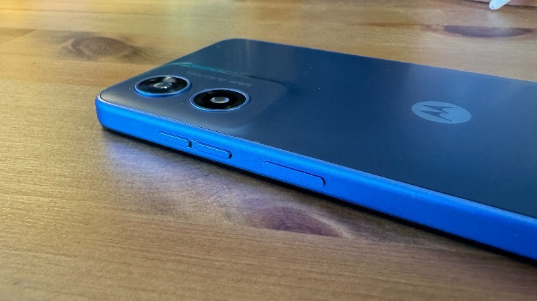 Blue Moto G Play (2024) tumbado boca abajo sobre una superficie de madera.