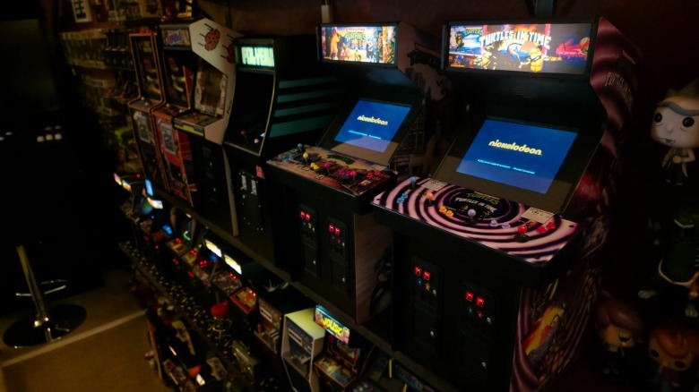 A collection of mini arcade cabinets with Quarter Arcades pieces on top and New Wave Toys pieces below.