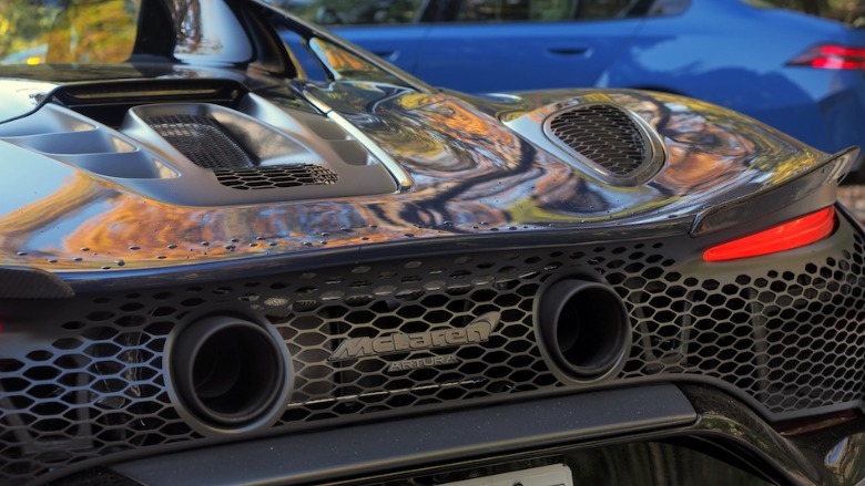 Close-up of McLaren Artura tailpipes with BMW M5 in background