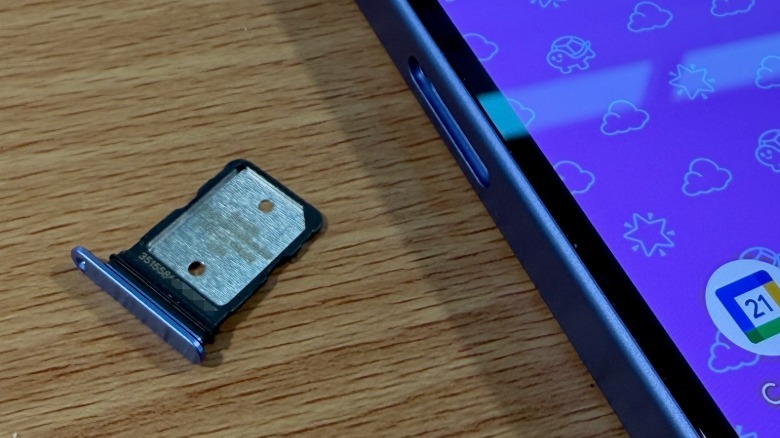 SIM card tray and phone on wood table top