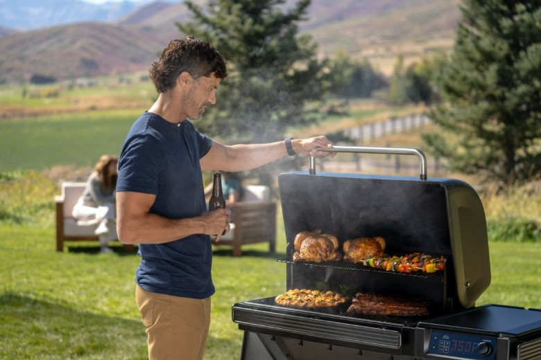 Person using a Traeger Woodridge grill.