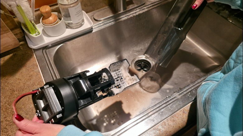 A person cleaning parts from the Aero Ultra Steam over a sink