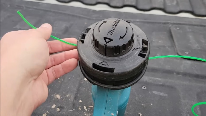 A closeup showing the restringing process for a Makita rapid load bump head string trimmer