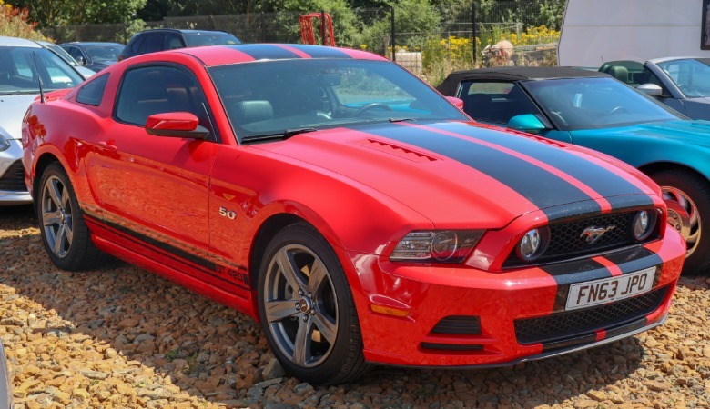 Red 2014 Ford Mustang GT parked on pebbles