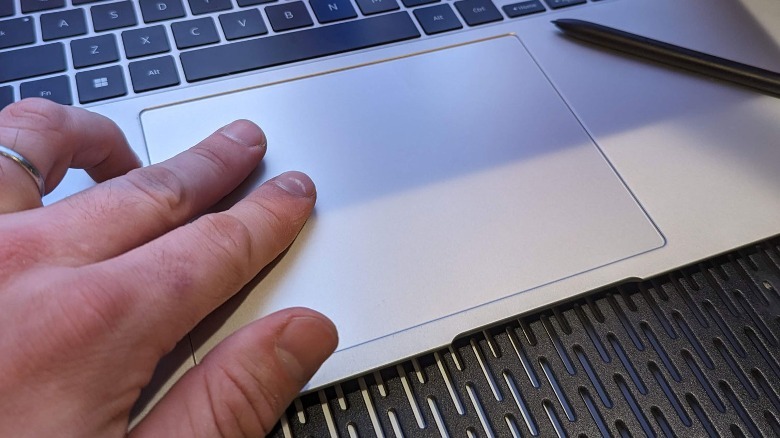 hand touching touchpad on computer
