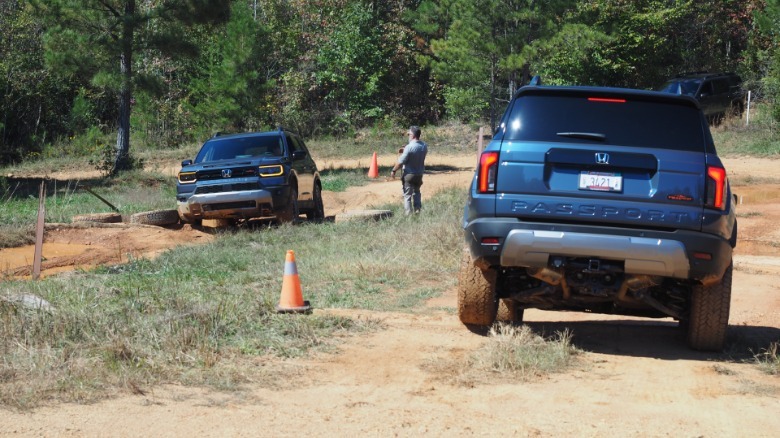 A pair of 2027 Honda Passport TrailSports navigate an off-road obstacle course
