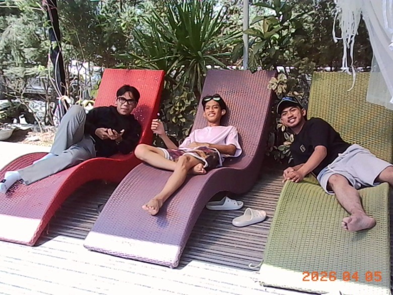 three people resting on lounge chairs by the poolside