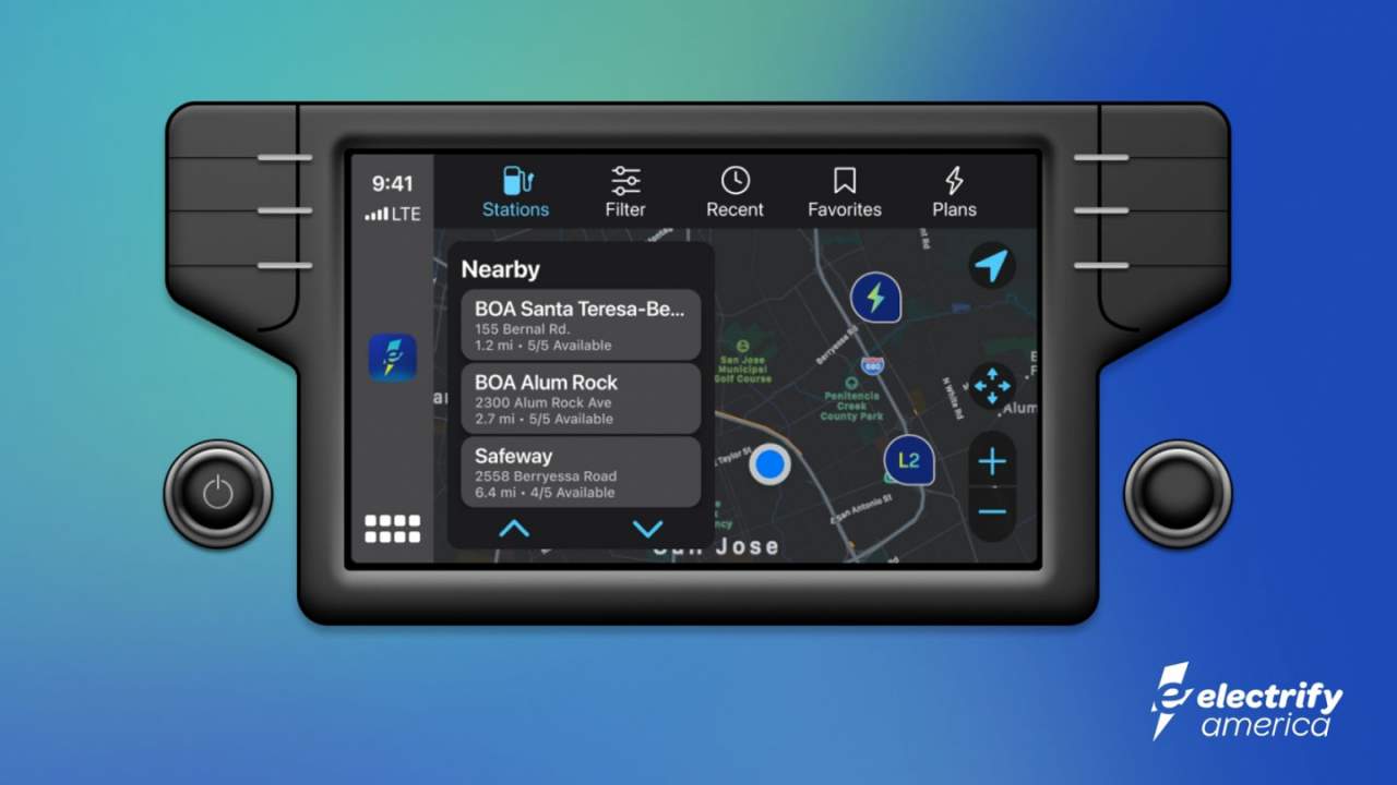 Electrify America App screen shown embedded in a simulated EV center binnacle. App display selections are across the top. Nearby chargers are listed in an overlay, and the preferred map fills the viewport. 